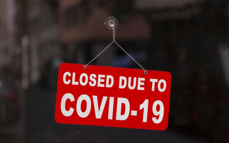 Closed shop sign that reads "Closure due to COVID-19"